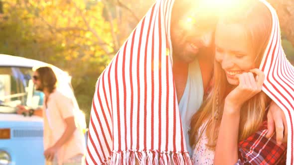 Couple hiding themselves under a scarf