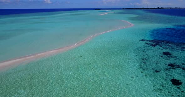 Beautiful overhead travel shot of a white sand paradise beach and blue ocean background in 4K