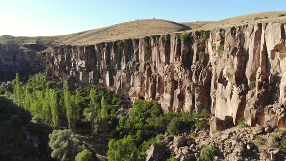 Aerial Deep Long Rift Canyon with Cleft Steep Rock Walls and High Cliff Gorge