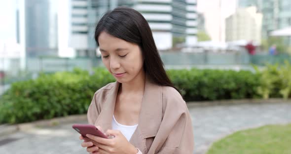 Asian woman sending sms on mobile phone