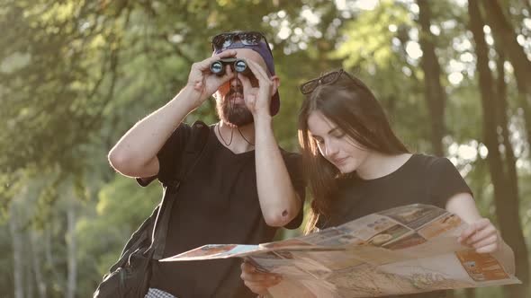 Couple of Hikers Standing in the Forest and Looking for Places