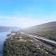 beautiful expressway in a green forest with a dam on the side of the road between mountains. - VideoHive Item for Sale