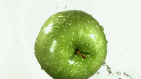 Flying of Green Apple in White Kitchen Background in Slow Motion