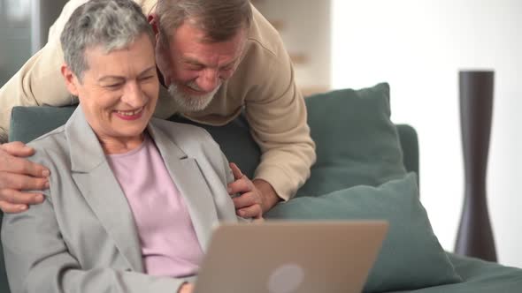 Happy Senior Elderly Couple Laughing Talking Making Remote Video Call Looking at Laptop Webcam