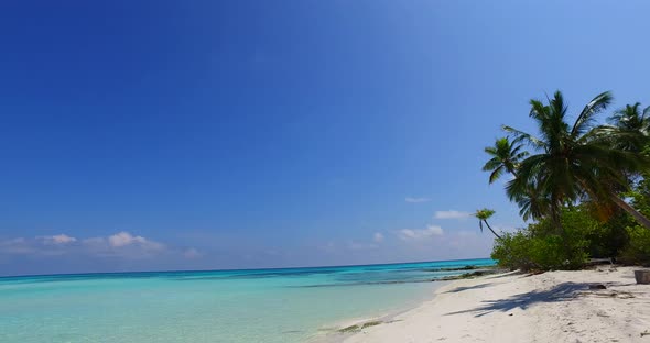 Tropical fly over tourism shot of a paradise sunny white sand beach and aqua turquoise water backgro