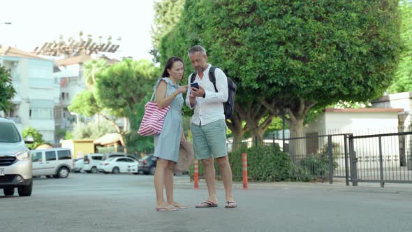 Couple of Tourists Using Smart Phone Gps in Street Search Locations