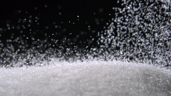 Pile of sugar on black background, Slow Motion alt