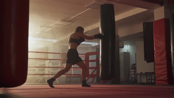 Kickboxing, Woman Fighter Trains His Punches, Beats a Punching Bag, Training Day in the Boxing Gym