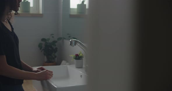 Woman leaning on the bathroom sink