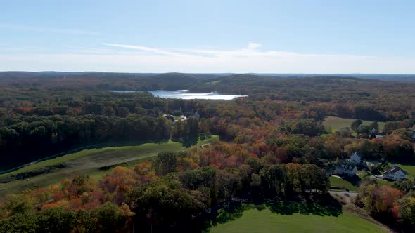 Autumn color forest and lake water reflection, town of Haverhill, USA. Aerial drone view