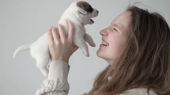 Girl Petting and Playing with a Small Puppy