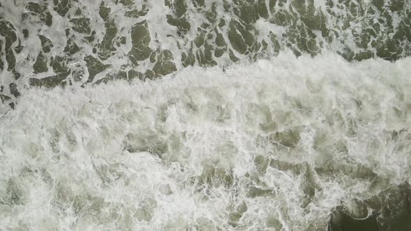 Slow-motion waves breaking bottom to top of frame Aerial