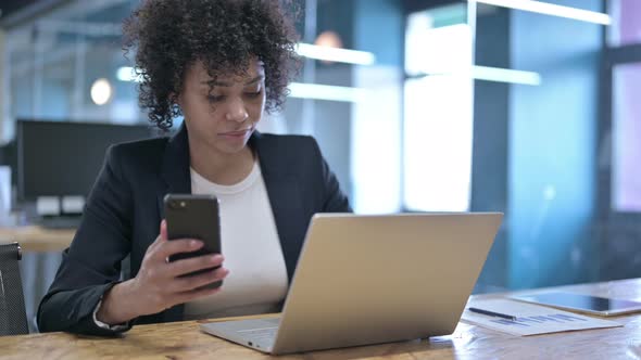 Serious Businesswoman Using Smartphone at Work