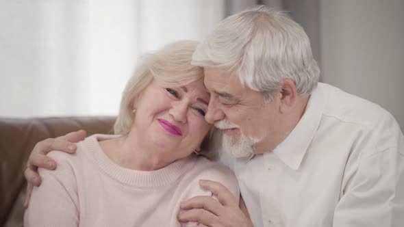 Portrait of Smiling Elderly Caucasian Spouses Looking at Camera, Joyful Mature Husband and Wife