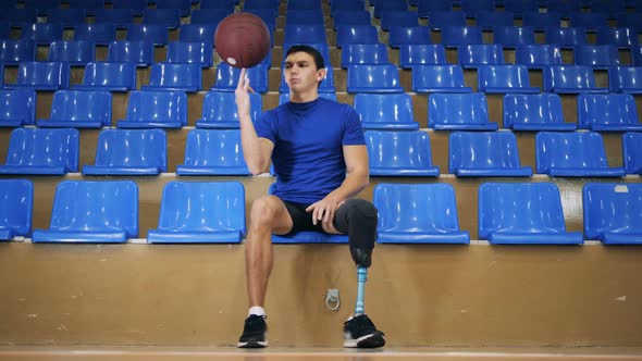 One Sportsman with Prosthetic Leg Holds a Ball in Hands, Close Up.