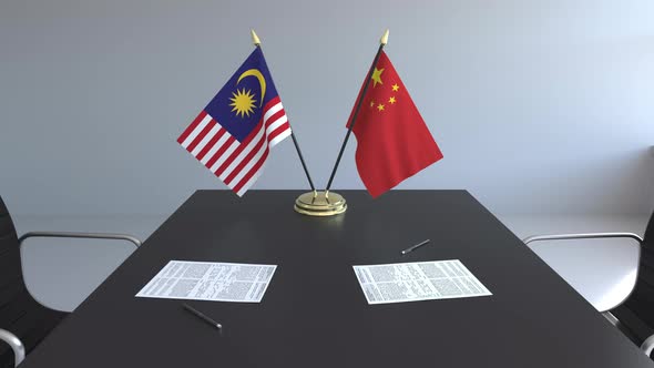 Flags of Malaysia and China and Papers on the Table alt