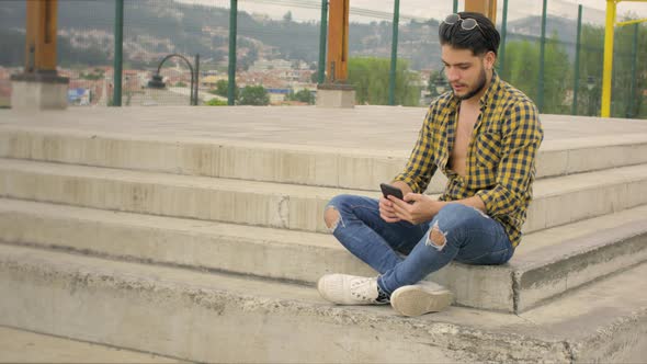 Handsome guy using cell phone in a park