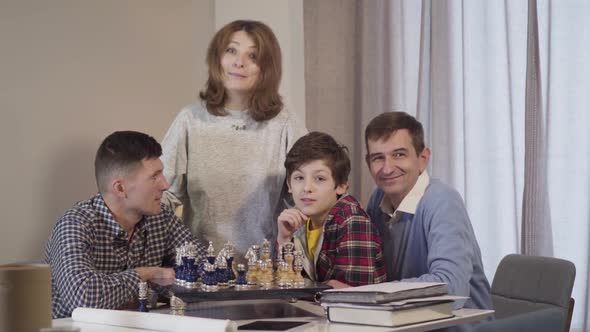 Four Caucasian People of Different Ages Looking at Camera and Smiling. Happy Little Boy, His Father