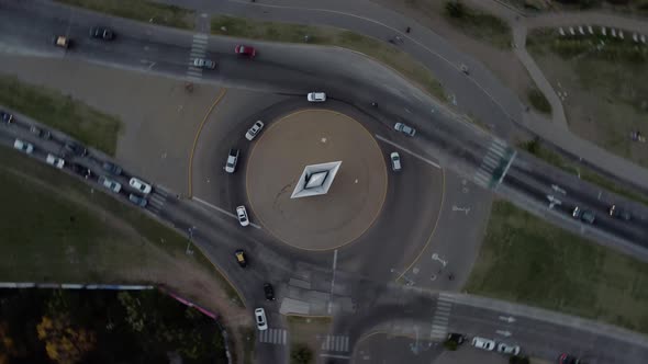 Aerial drone top rotating shot over a road crossing in Rosario, Argentina during evening time with c