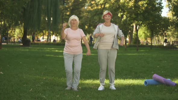 Mother and Her Daughter Doing Exercises in Park, Warming Up Before Workout