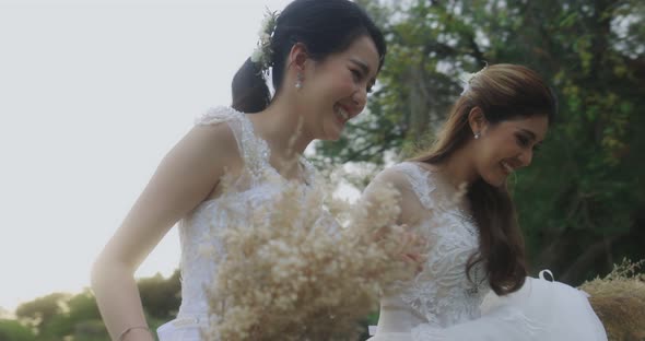 Slow Motion Asian Lesbian Married Couple Holdings Hands And Running Together.