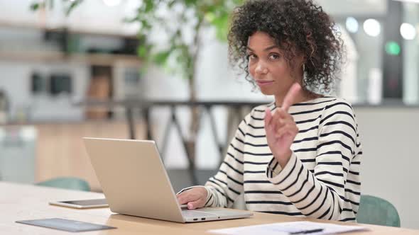 African Woman with Laptop Saying No By Finger Sign