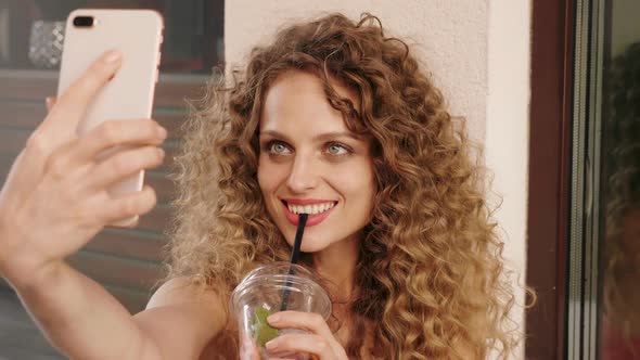 Woman in summer trendy clothes sitting in veranda cafe