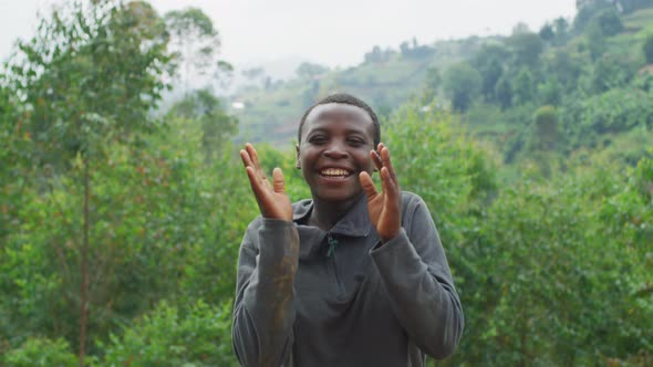 Young African woman jumping and clapping hands