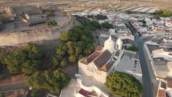 Pan right aerial shot around historical Church of Our Lady of Martyrs in Castro Marim, Algarve.