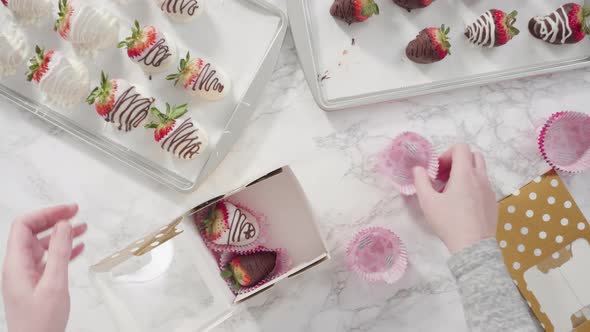 Flat lay. Step by step, Packaging chocolate dipped strawberries into a paper box for a gift