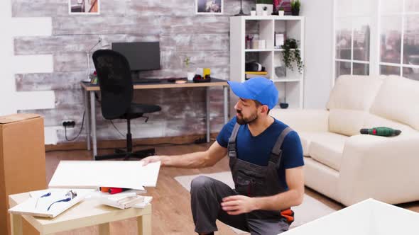 Male Worker Mounting a Shelf on New Furniture