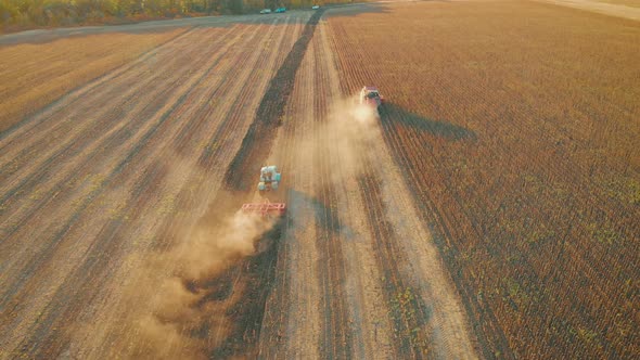 Aerial View Modern Red Tractor on the Agricultural Field on Sunset Time. Tractor Plowing Land and