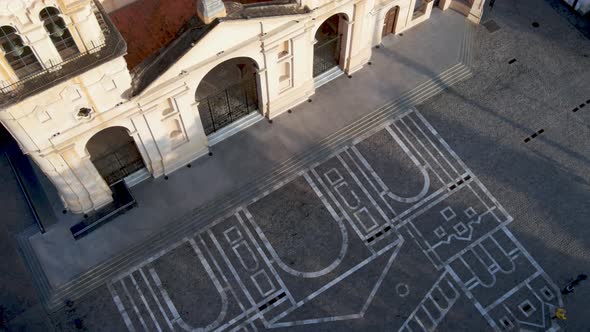 Aerial pan of of Córdoba Cathedral and painting on ground, Argentina