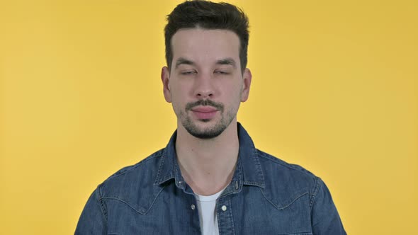 Portrait of Cheerful Young Man Saying Yes By Shaking Head, Yellow Background