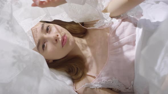 Beautiful Woman Lying in Bed with Canopy on Peaceful Morning