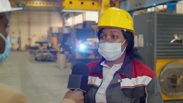 Female Factory Worker in Mask Giving Interview to Reporter