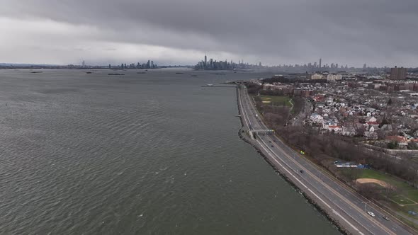 An aerial view high over the waters of Upper Bay in Brooklyn NY. The drone camera dolly in and boom