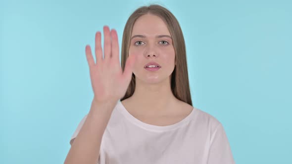 Stop Gesture By Beautiful Young Woman, Blue Background