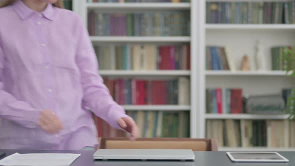 Woman Coming Back Opening Laptop in Office