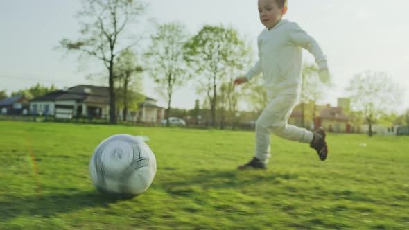 Happy Childhood Slow Motion Video of Children Playing Soccer on the Grass