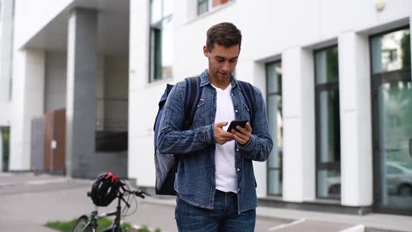 Cheerful Young Courier Man Working Checking Delivery Address Looking Phone Leaves Bicycle in City