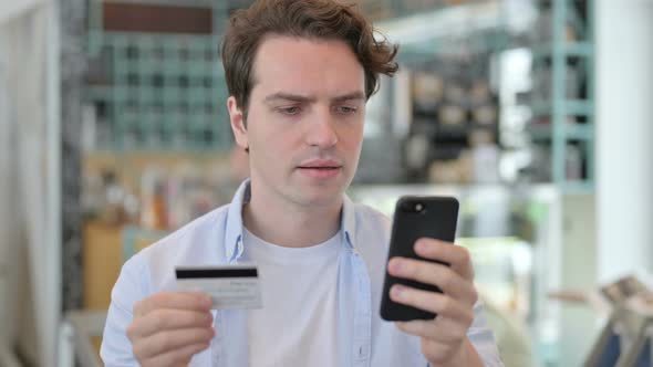 Portrait of Young Man with Unsuccessful Online Payment on Smartphone