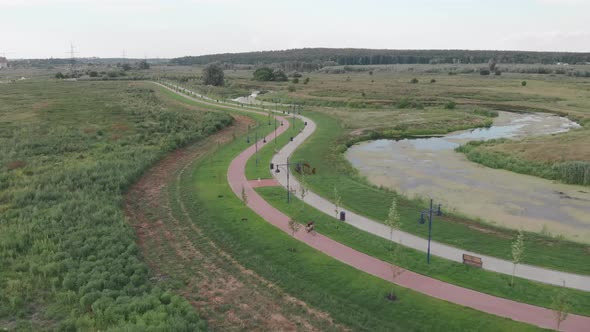 Motivated sportive female athlete is speeding forward on bicycle cycle path along promenade