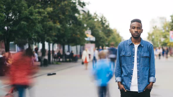 Time-lapse of Lonely African American Guy Student Standing in Pedestrian Street in Big City with