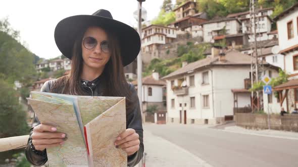 Travel Girl with Touristic Map in Shiroka Laka, Bulgaria. Happy Women Enjoy Bulgarian Vacation