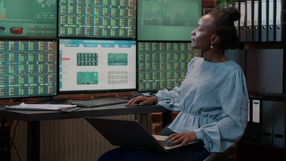 Female Investor Looking at Real Time Stocks on Laptop and Multiple Monitors