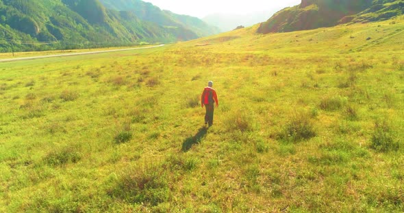 Flight Over Backpack Hiking Tourist Walking Across Green Mountain Field