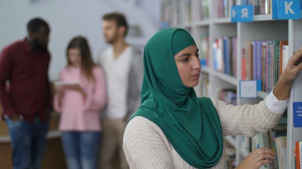 Muslim Student Searching for a Book in Library