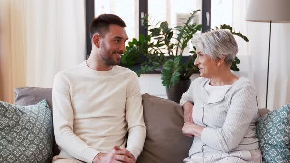 Senior Mother Talking To Adult Son at Home