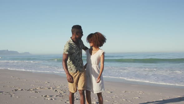 African American couple walking side by side at beach